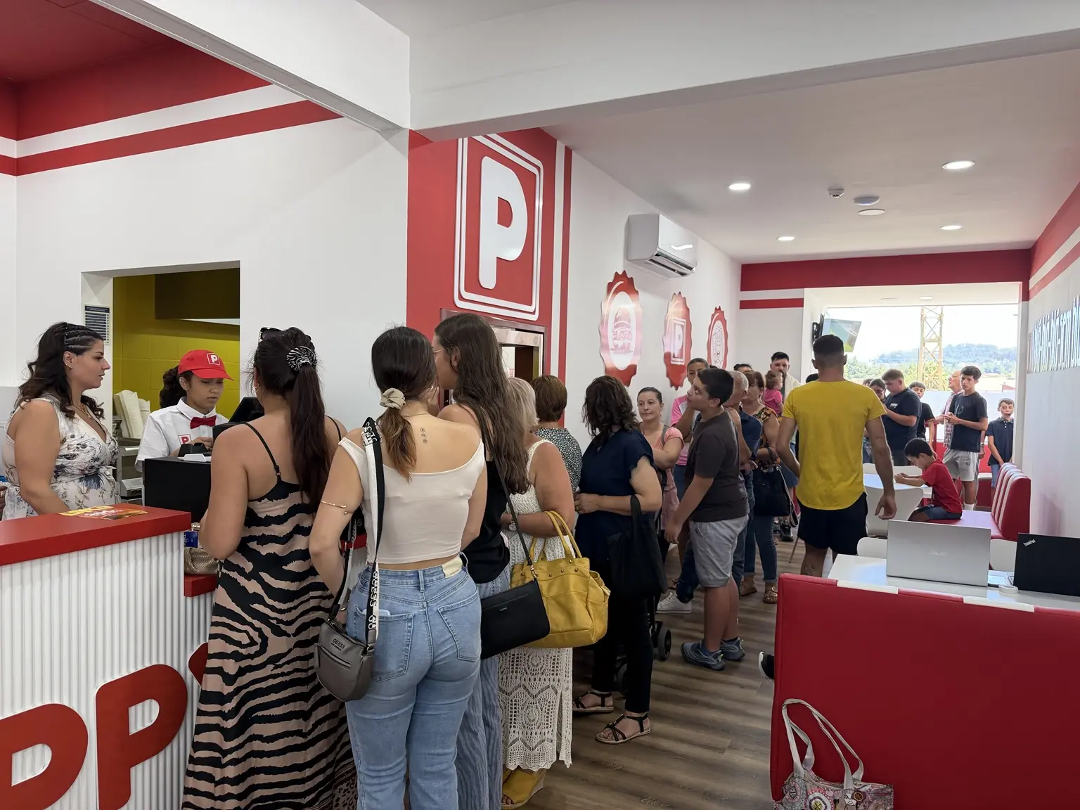 Fila de clientes e equipa em operação numa unidade POPPYS